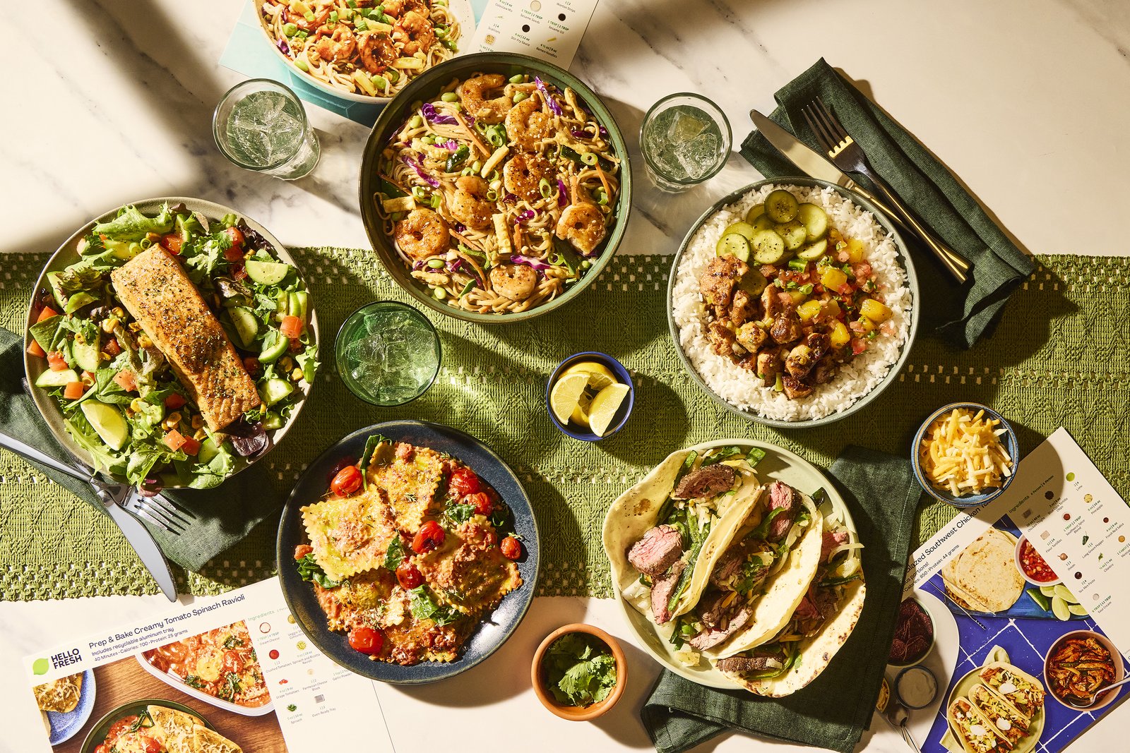 An overhead table of HelloFresh dinners: noodles, ravioli, steak tacos and a rice bowl